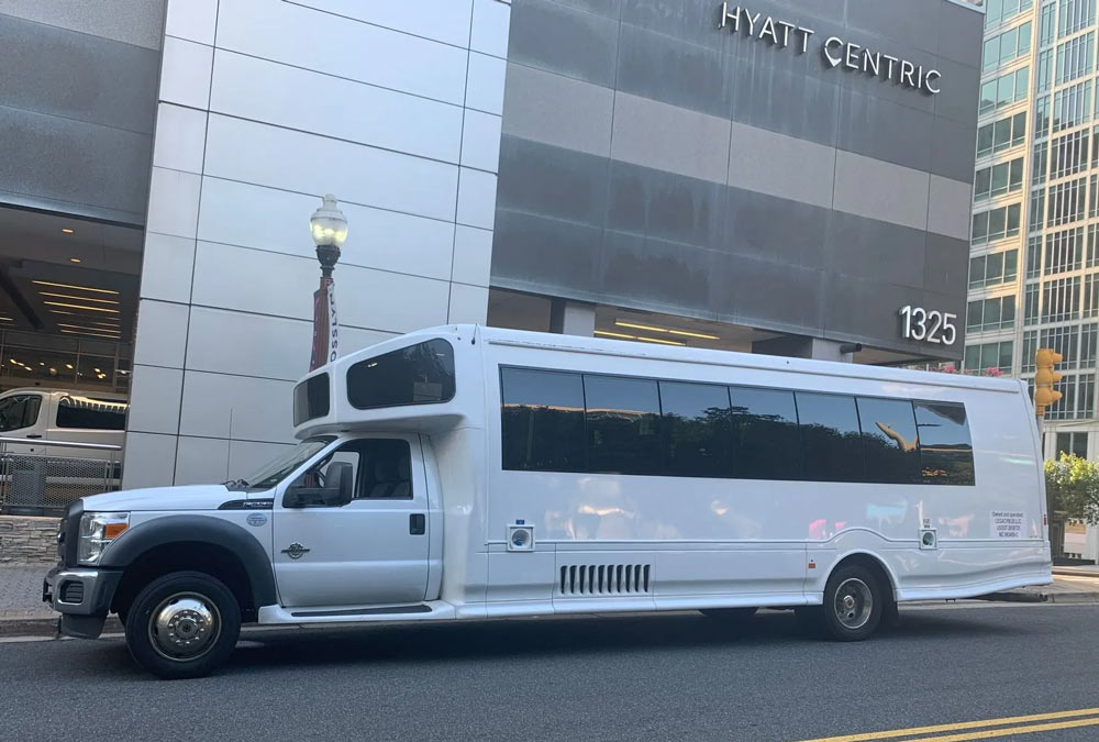 A white bus driving through a city street in Maryland