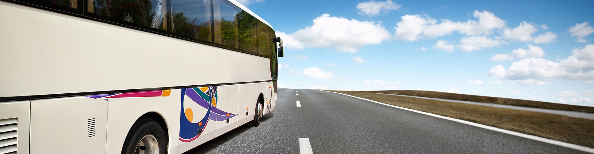 A bus driving down a road next to a Virginia forest