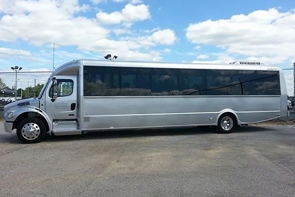 A white bus in a spacious Virginia parking lot for charter services