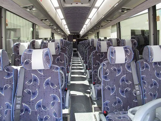 A row of seats featuring blue and white stripes on a bus rental