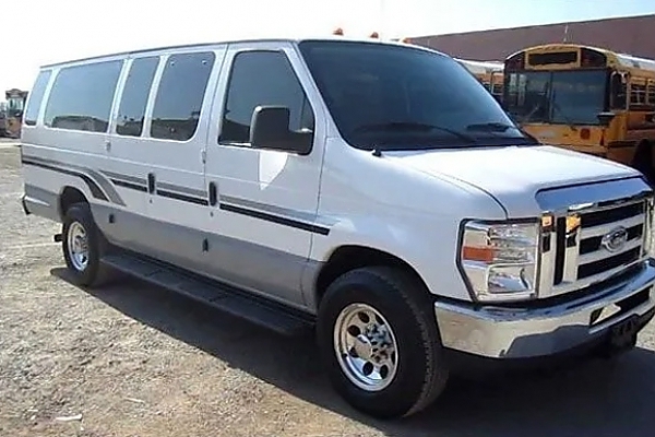 A white bus parked in a Virginia parking lot for rental services