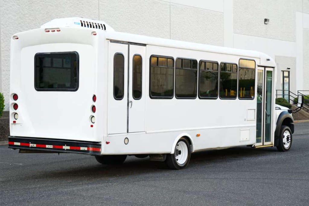 A white and blue bus in a parking area for Washington, DC charters