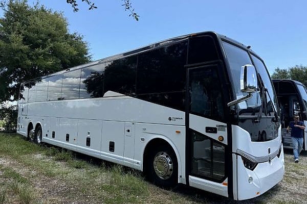 A large white bus in a North Carolina field for group trips