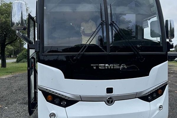 A white bus in a Chicago parking lot for charter services