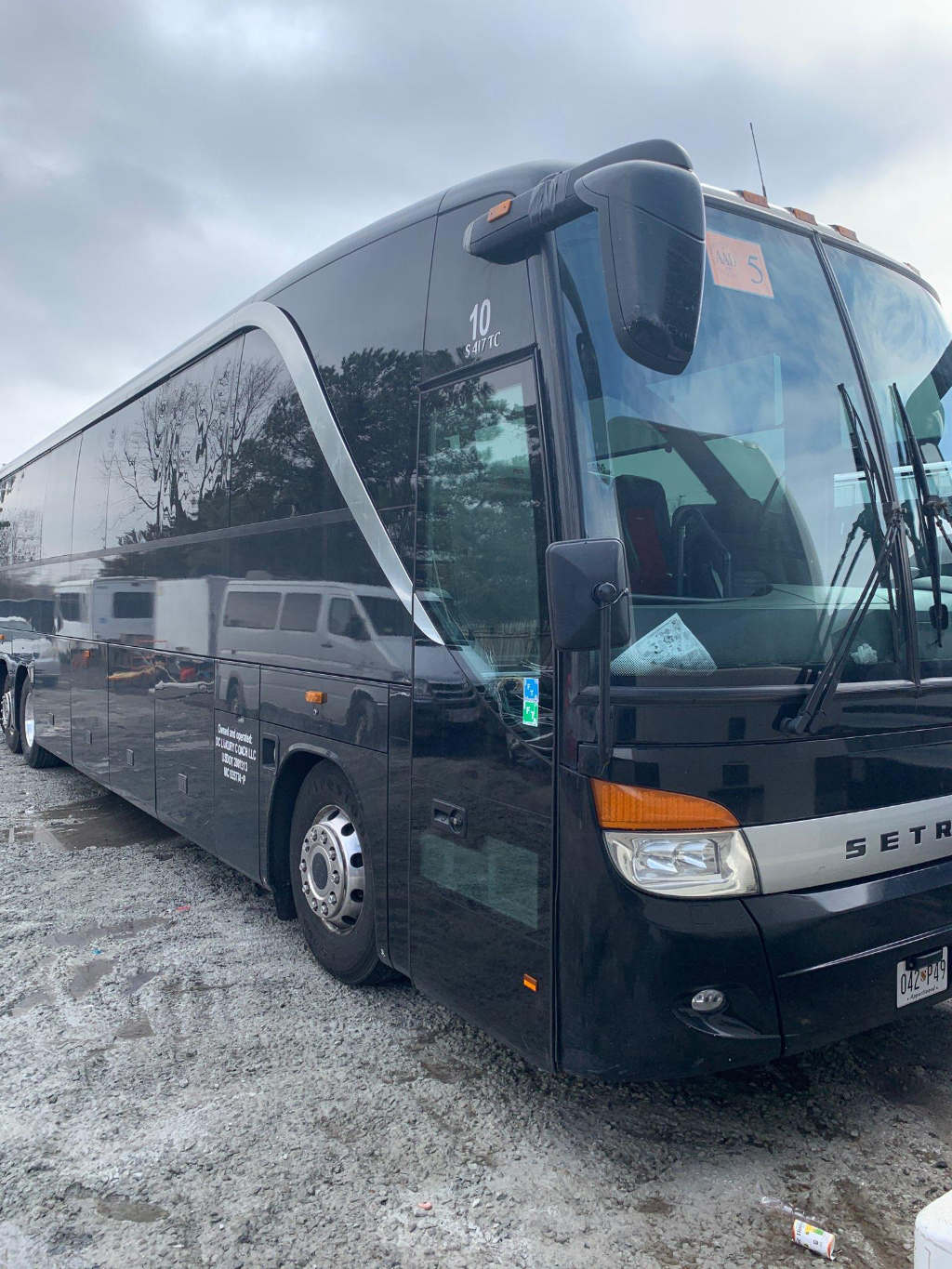 A bus parked in a wooded area for outdoor charter trips