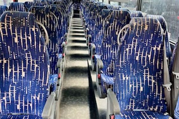 A row of blue and white buses in a New York parking area