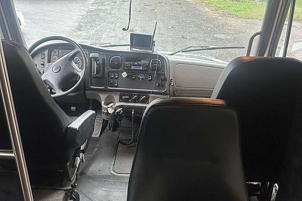 A row of seats on a bus with large windows for scenic travel